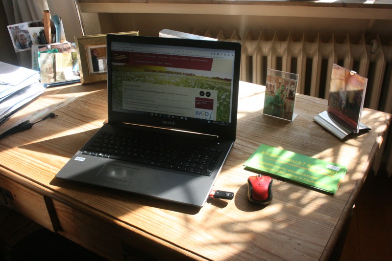 Laptop auf Holztisch für Online-Sprechstunden