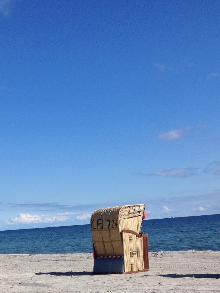 Einzelner Strandkorb vor blauem Himmel